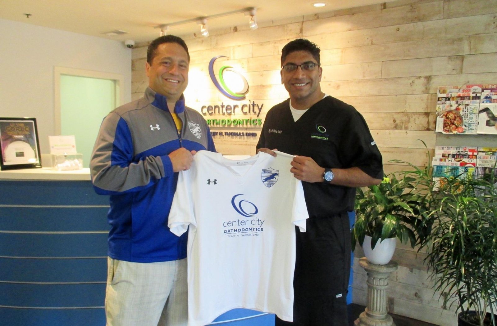 Dr. Thomas presenting a sponsored team shirt
