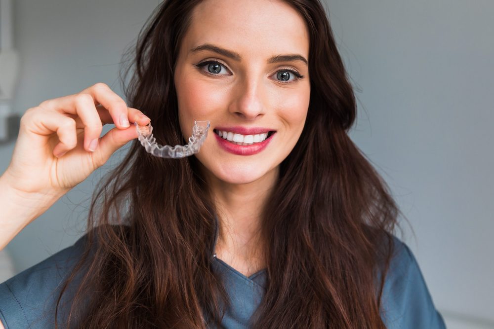 Woman holding a clear aligner