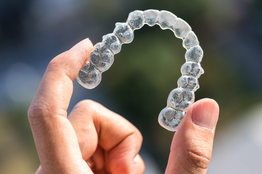 Hand holding a clear aligner