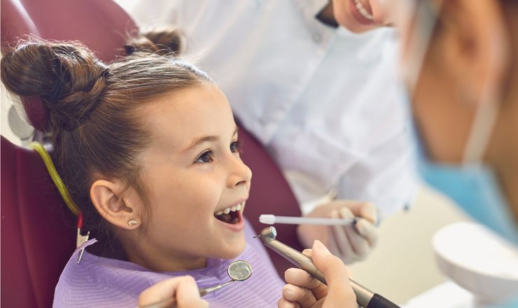 A young girl smiling in the dental chair during a check-up